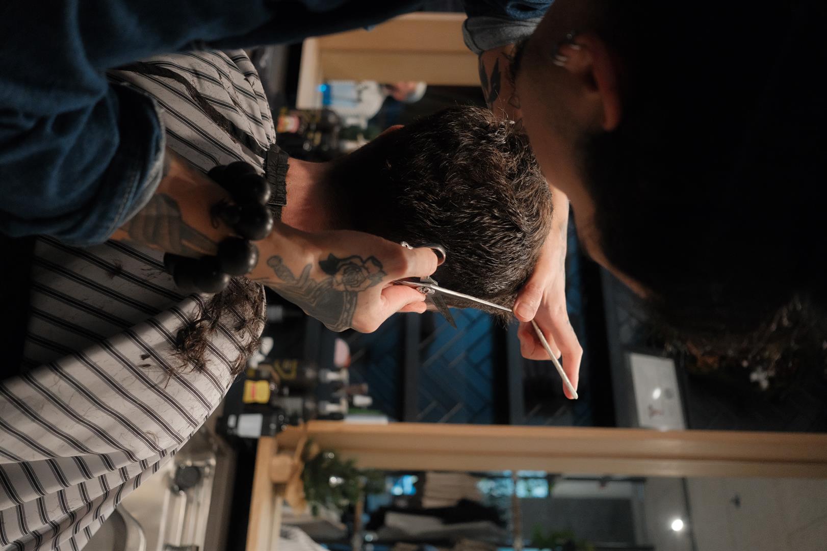 Sorek barber giving a groom a pre-wedding scissor cut